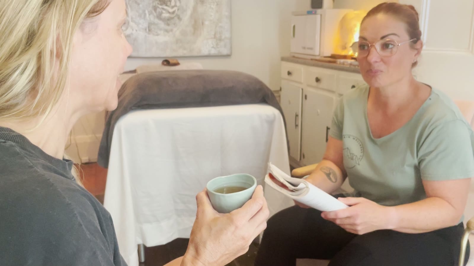 Jodie sitting with a client over tea, talking through what they need that day